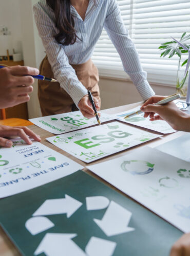 Business team analyzing environmental, social, and governance strategy during a meeting with charts and graphs showing key performance indicators